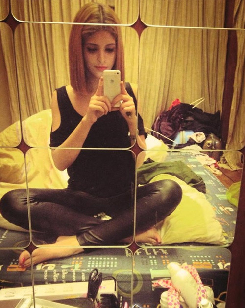 Andrea vô tư chụp ảnh mà không hề bận tâm đến căn phòng bừa bộn như “bãi chiến trường” đằng sau.