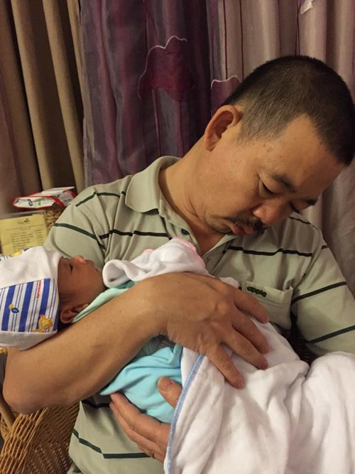 Vì bận ẵm con nên ông bố này phải ngủ gà ngủ gật.