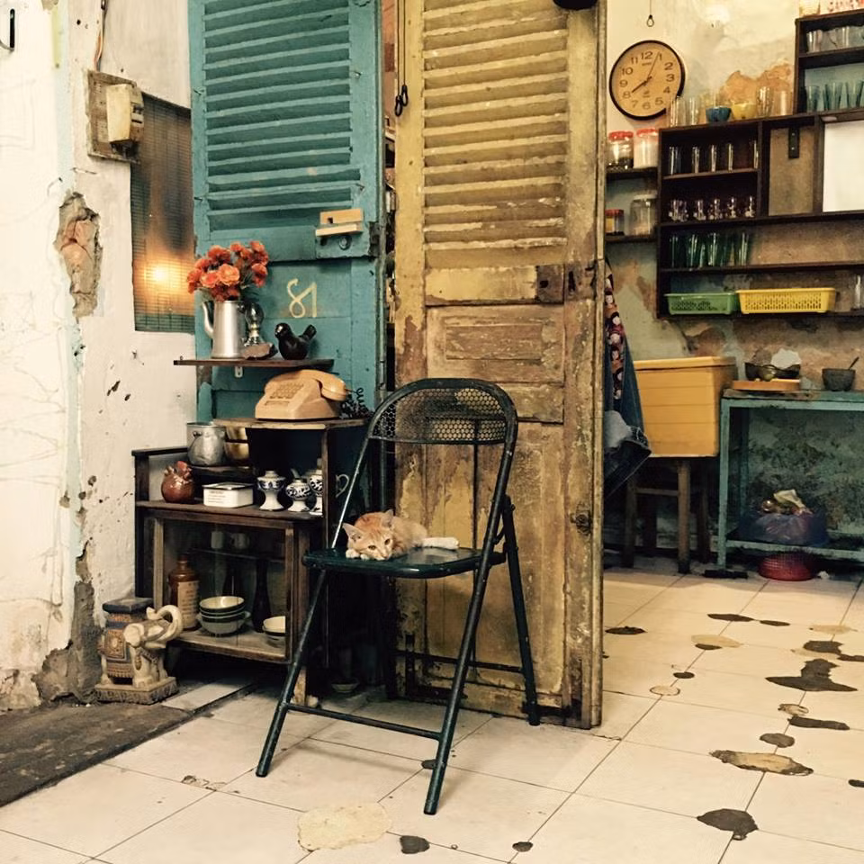 Quán nằm ngay "mặt tiền", nhưng nhìn như một ngôi nhà cũ hay một tạp hóa ngày xưa, nếu không để ý đến dòng chữ "Cửa hàng cà phê 81" được vẽ trên tấm bảng gỗ treo trước cửa.