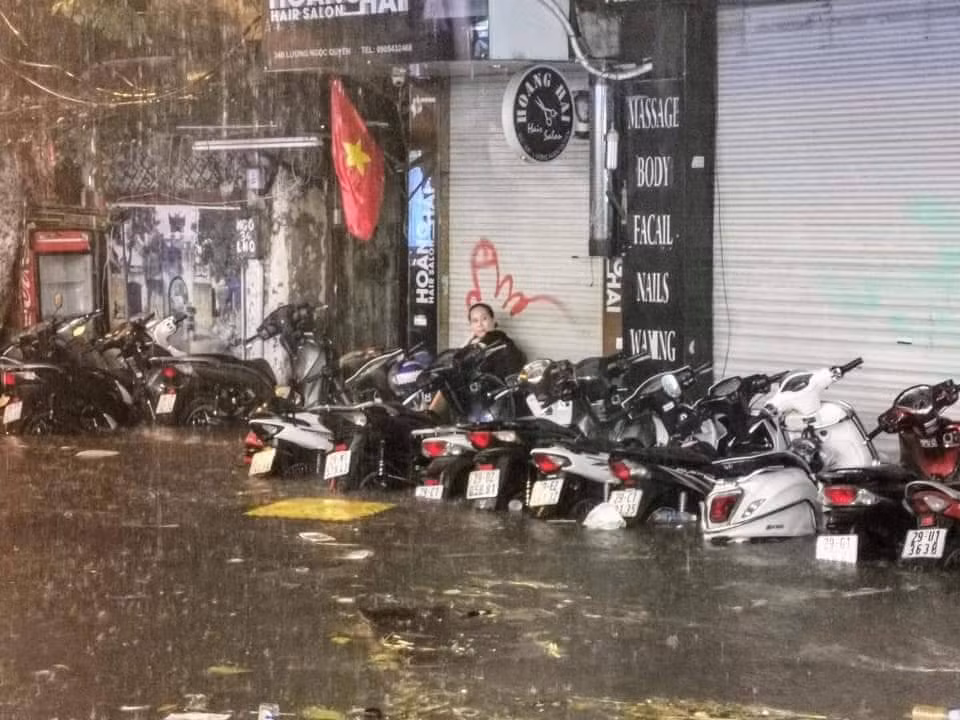 Mưa khiến rác thải tràn về khu trũng và miệng cống nên nhiều chủ cửa hàng phải vất vả dọn dẹp và che chắn.