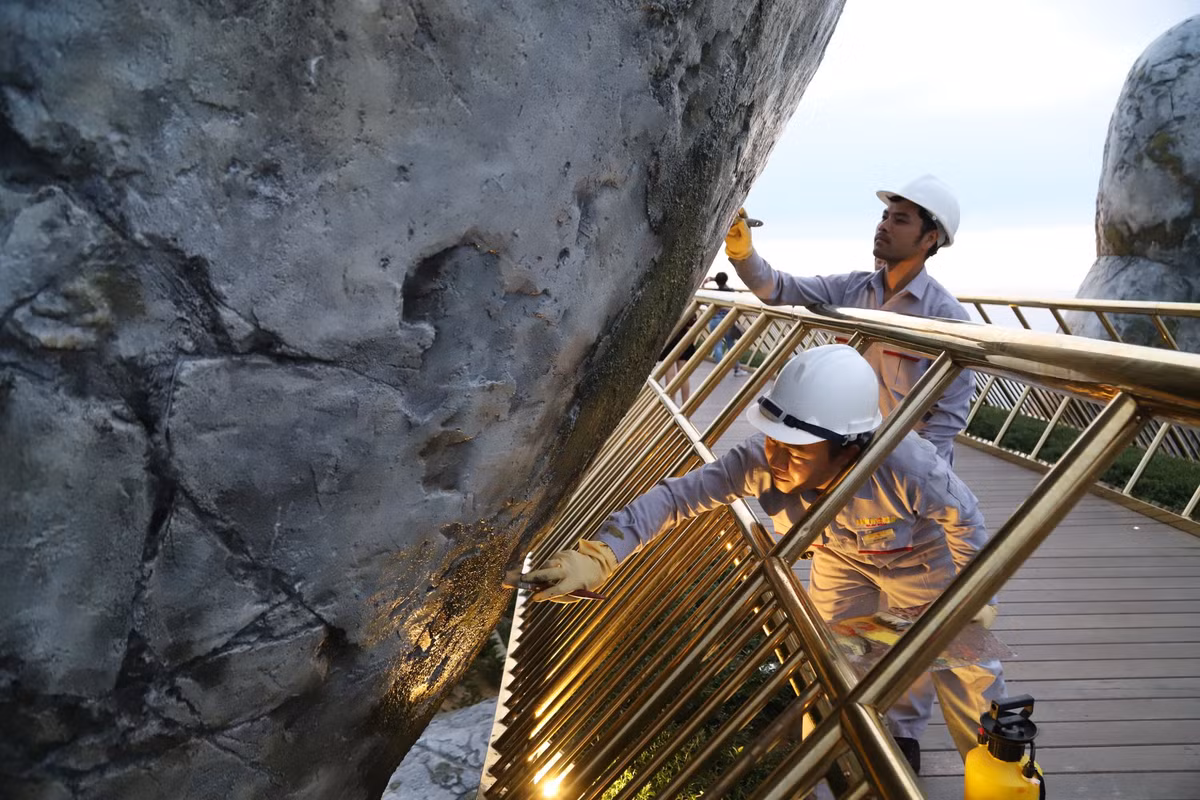 Dù chỉ là một dòng chữ nhỏ nhưng có thể thấy đã phải có 2 người công nhân cùng nhau góp sức để lấy lại vẻ đẹp ban đầu cho cây Cầu Vàng ở Đà Nẵng.