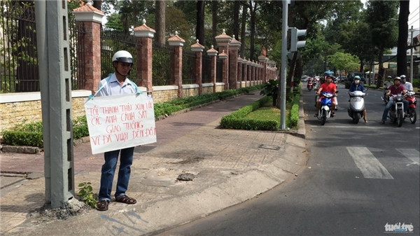 Chỉ vì cậu con trai nhắc nhở khi vượt đèn đỏ, ông bố nghiêm túc đã đeo tấm biển xin lỗi của mình đến toàn thể người tham gia giao thông.