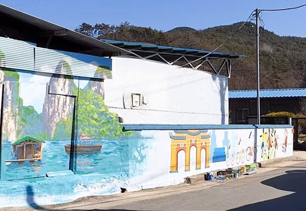 Không chỉ là hình ảnh các cầu thủ Việt và HLV Park, những hình ảnh đặc trưng, danh lam thắng cảnh của Việt Nam như áo dài, Khuê Văn Các hay vịnh Hạ Long cũng được khắc họa sinh động trên những bức tranh vẽ tường.