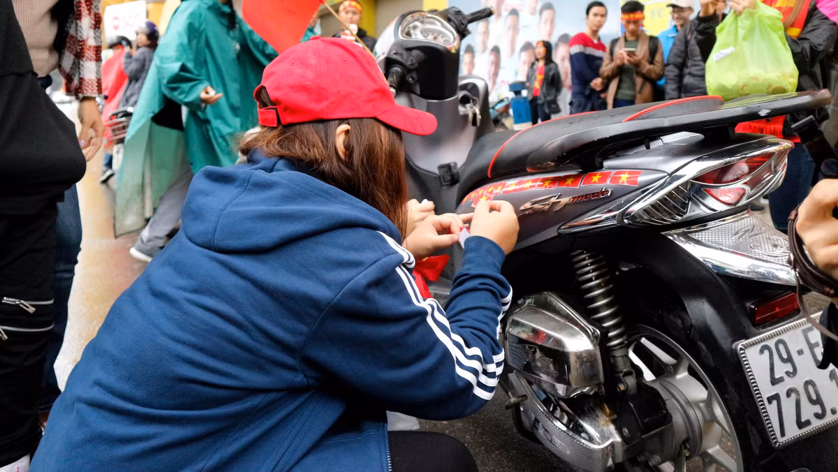 Các bạn trẻ tranh thủ tút tát lại chiếc xe của mình cho thật độc đáo để chuẩn bị cho cuộc diễu hành quanh các con phố Hà Nội sau khi trận chung kết của các cầu thủ U23 Việt Nam kết thúc.