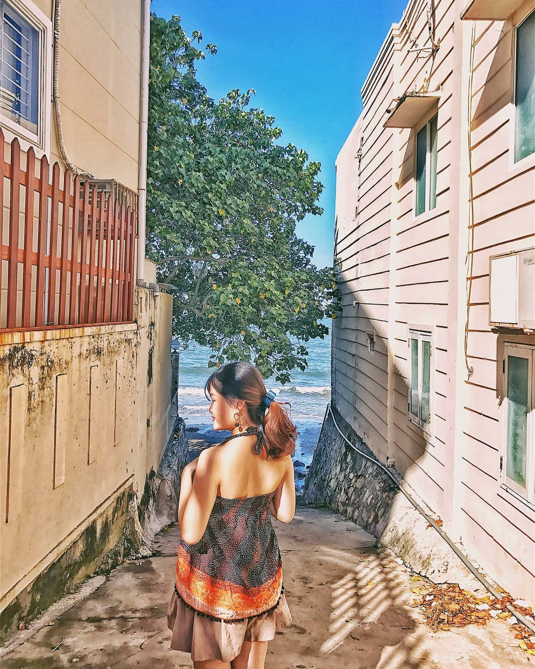 Con hẻm này khá nông và dẫn thẳng ra biển, hai bên là hai bức tường màu vàng pastel trông nhẹ nhàng và khá bắt mắt.