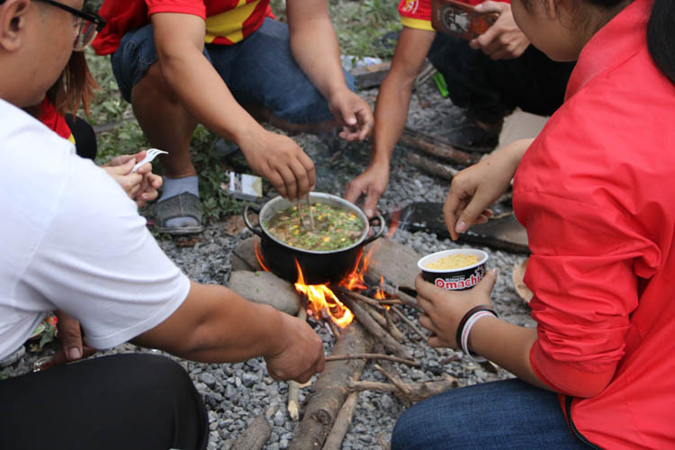 Trong lúc khó khăn khi lương thực trên xe chỉ là những cốc mì, các CĐV Việt Nam đã phải sử dụng đến "bản năng sinh tồn" của mình. Một bếp ăn "dã chiến" đã được lập lên ngay giữa rừng núi đại ngàn của nước bạn Lào.
