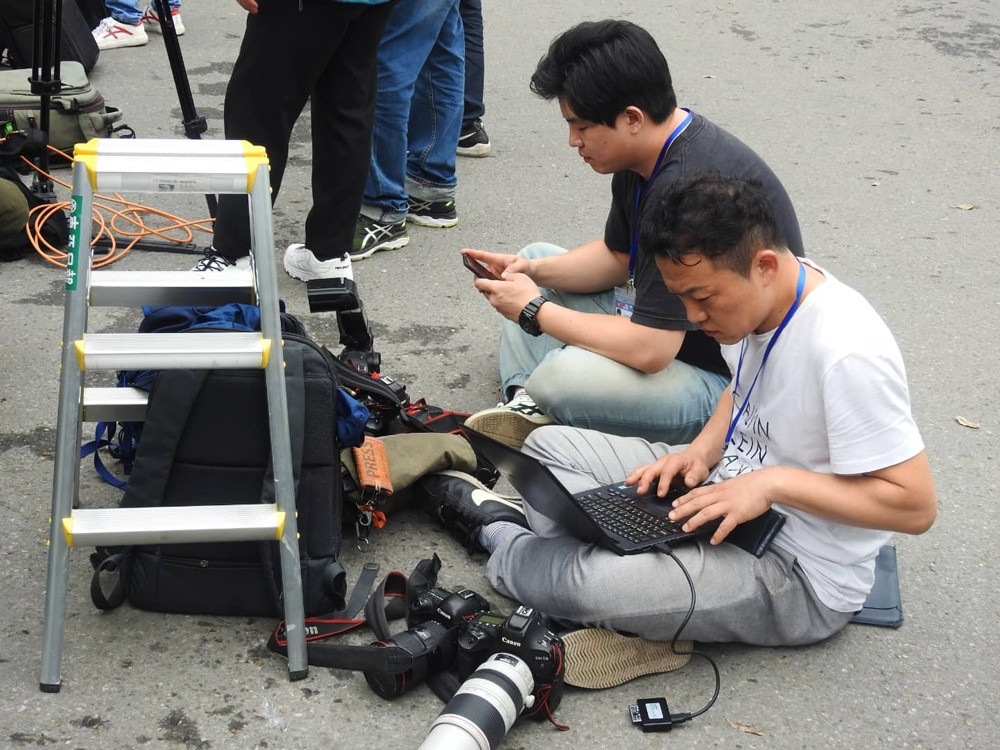 Ngồi lòng đường, vỉa hè, góc phố để nhanh chóng gửi tin bài về là điều quen thuộc của các phóng viên "chiến trường" được các dân mạng ghi lại.