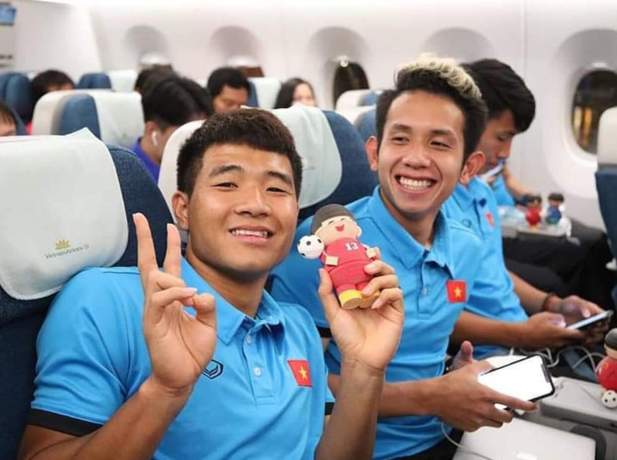 Đức Chinh tạo dáng chụp ảnh bên chú búp bê của mình ở khoang phổ thông.