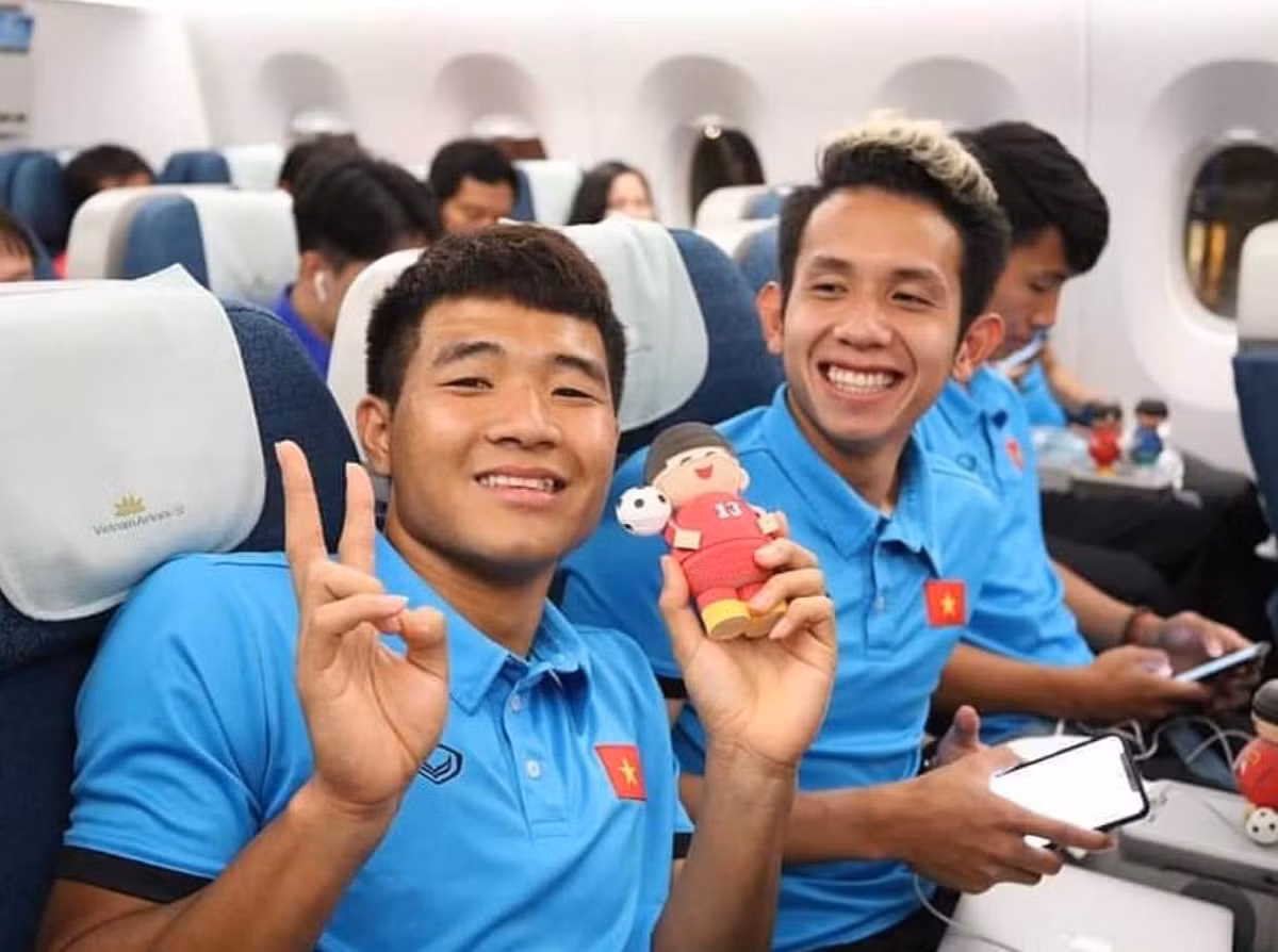 Đức Chinh tạo dáng chụp ảnh bên chú búp bê của mình ở khoang phổ thông.