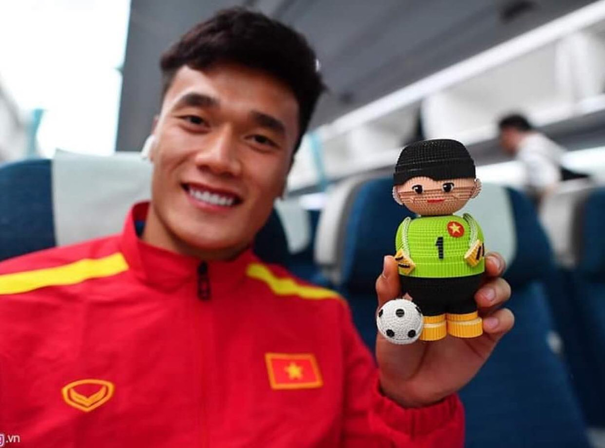 Thủ môn Bùi Tiến Dũng thích thú với chú búp bê mang số áo của mình.