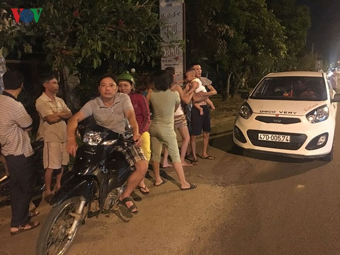 Người dân quan sát việc khám xét từ phía bên kia đường (ảnh: Quốc Học - Tuấn Long)