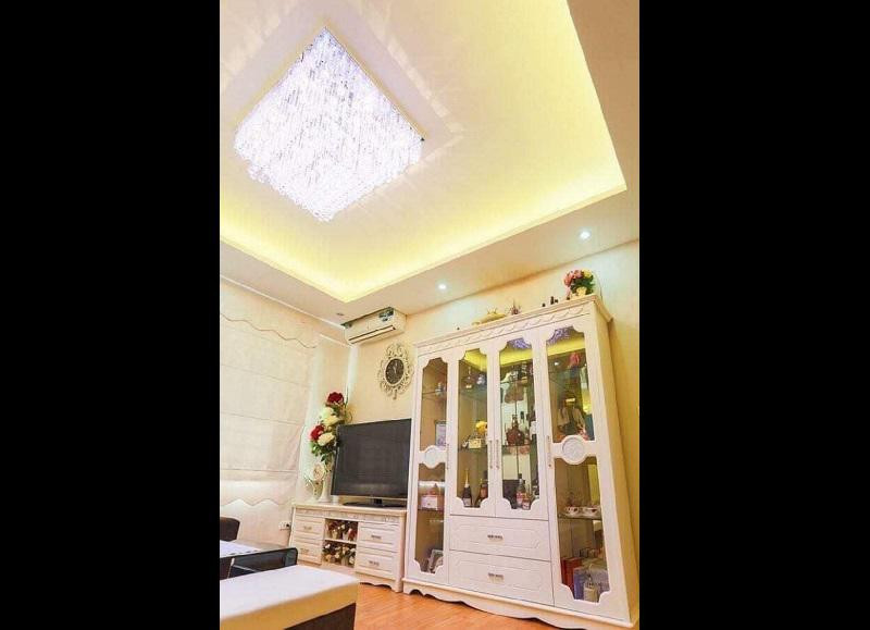 Phòng khách sang trọng với đèn chùm, kệ tủ dọc giúp tiết kiệm diện tích.