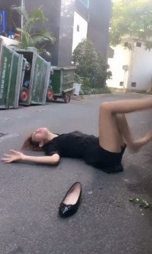 Trong clip, cô gái mặc áo sơ mi đen ngồi bên vệ đường với khuôn mặt bí xị vì "mấy hôm rồi không có ly trà sữa nào vào bụng".