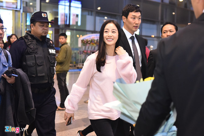 Cô liên tục vẫy tay, đồng thời nhận hoa, nón lá và quà từ người hâm mộ. Nữ diễn viên 38 tuổi trẻ trung trong trang phục hồng nhạt. Cô trang điểm nhẹ nhàng.