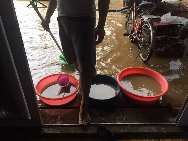 Người dân Nghệ An phải lấy xô, chậu tát nước từ trong nhà ra ngoài. Ảnh: Huyền Hym