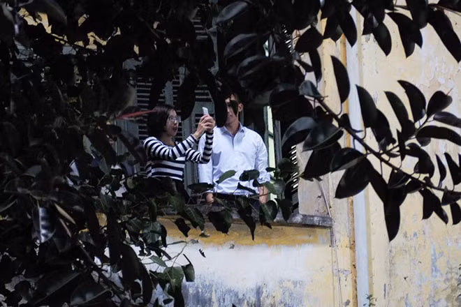 Một cặp đôi tranh thủ ban công nhà mình để xem trận đấu giữa ĐT Việt Nam và Campuchia.