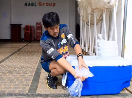 Ở đường hầm vào sân, vị trợ lý này cho đá vào trong các túi nilon và đổ nước dư ra.