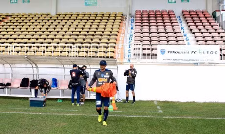 Một trợ lý đang đem marker vào bố trí trong sân theo giáo án từng bài tập của HLV trưởng.