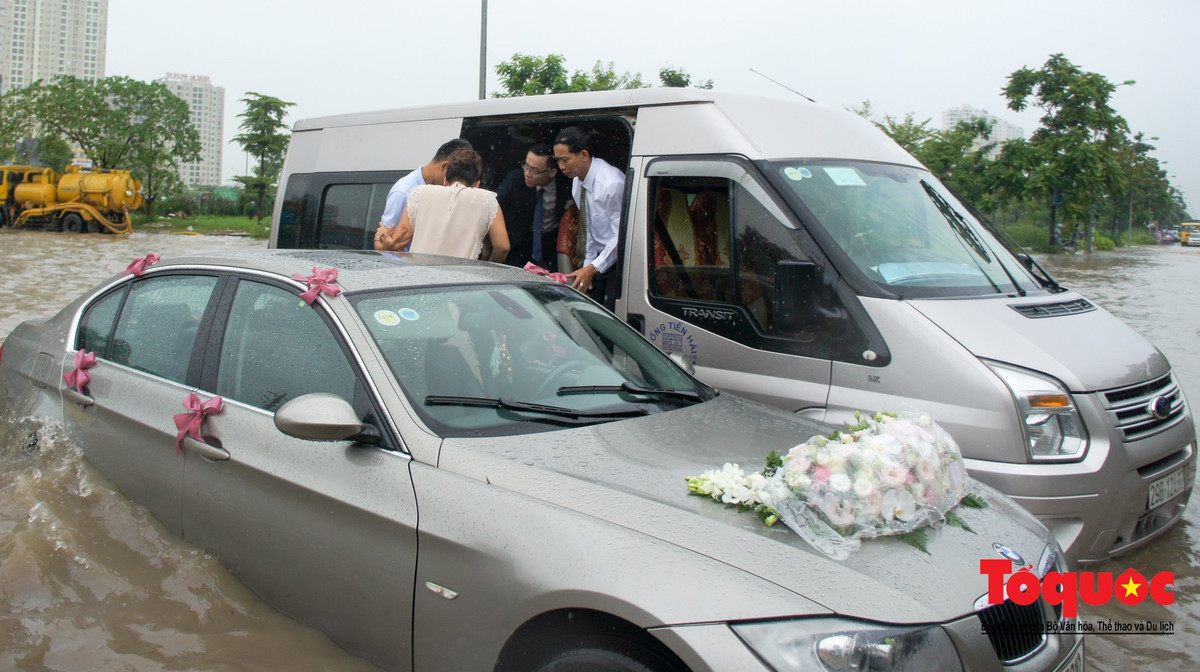 Đám cưới ngày mưa lũ cũng chẳng giống ai. Khi xe đón dâu phải gọi một chiếc xe khác đưa cô dâu về nhà chồng. Ảnh: Nam Nguyễn (Tổ Quốc)