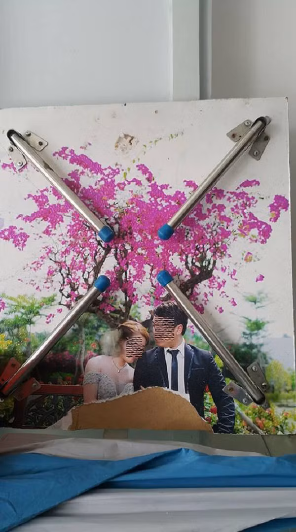 Tấm hình cưới này đã bị rách lại còn không cả được cho lên mặt bàn.