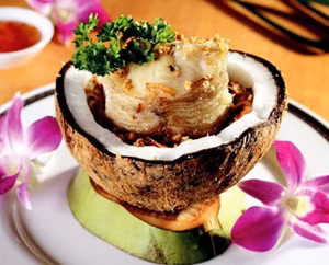 Dùng dao khứa chéo thân cá, có thể xắt nhỏ, ướp cùng gia vị bột nêm, hạt tiêu, tỏi, sả đã băm nhuyễn phi thơm trước khi cho vào nồi hấp. Đun sôi nước cốt dừa rồi rưới lên cá, bắc lên nồi đun sôi, khi gần được bạn cho hành tây đã xào thơm vào. Ảnh: Huggies.com.vn.