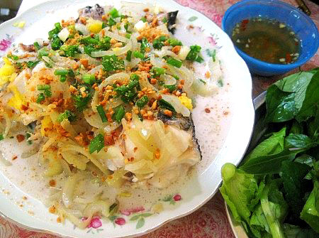 Khi chín bỏ hết cá cùng nước sốt đó vào quả dừa rồi rắc đậu phộng lên, đậy nắp dừa lại, khi ăn mới múc ra cho nóng. Món ăn này ăn kèm với rau sống cuốn bánh tráng chấm với nước mắm tỏi ớt rất ngon. Ảnh: cakholangvudai.org.