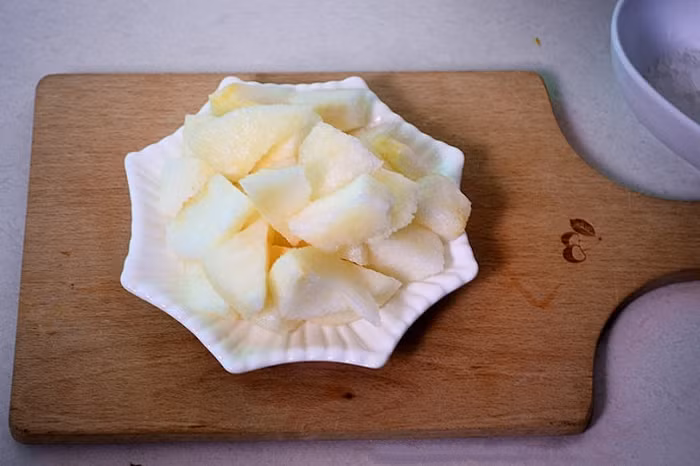 Chè lê chanh leo. Nguyên liệu cần chuẩn bị gồm 1 quả lê, 2 quả chanh leo, đường phèn tùy vị. Đầu tiên, gọt vỏ lên thái miếng và cho vào nồi cùng lượng nước vừa ăn. Ảnh: Toinayangi.