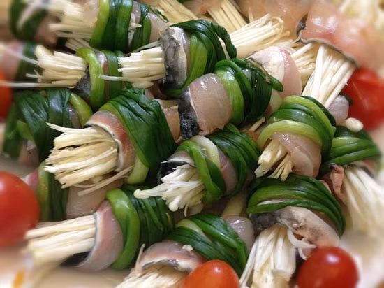 Chiên sả vàng, có độ giòn. Nhúng hành lá với nước sôi rồi bỏ ngay vào nước đá lạnh. Cắt phi lê cá, khử mùi bằng rượu trắng. Trải rộng miếng cá chẽm vừa cắt. Đặt một miếng măng, một cọng cải thìa vào giữa miếng cá, cuộn lại. Dùng hành lá cột miếng cá lại. Làm lần lượt đến hết. Ảnh: congthucmonngon.com.