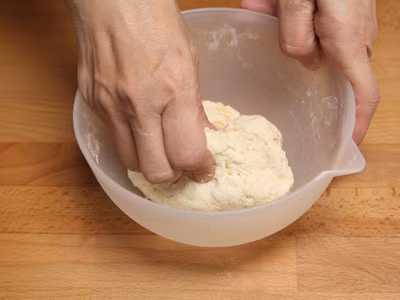 Cho từng ít nước vào và dùng tay nhào đều cho đến khi thu được hỗn hợp bột dẻo, quyện. Chia khối bột thành các phần nhỏ và viên tròn. Đun nóng dầu trong 1 nồi sâu lòng, sau đó lần lượt thả các viên bánh vào chiên ngập dầu từ 3-4 phút cho đến khi bánh chín vàng đều. Ảnh: aFamily.vn.