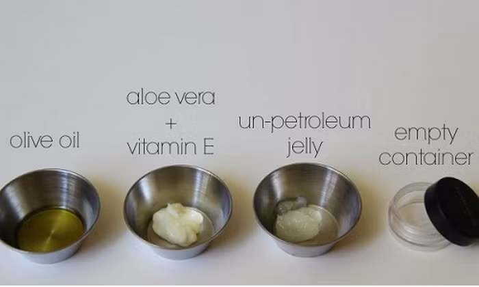 Vaseline, lô hội, vitamin E. Nguyên liệu gồm ½ thìa dầu oliu, 1 thìa gel lô hội, 1-2 viên vitamin E, 1 thìa Vaseline. Trộn đều các thành phần trong hộp đến khi chúng thành hỗn hợp mịn và quyện lấy nhau. Ảnh: Emdep.