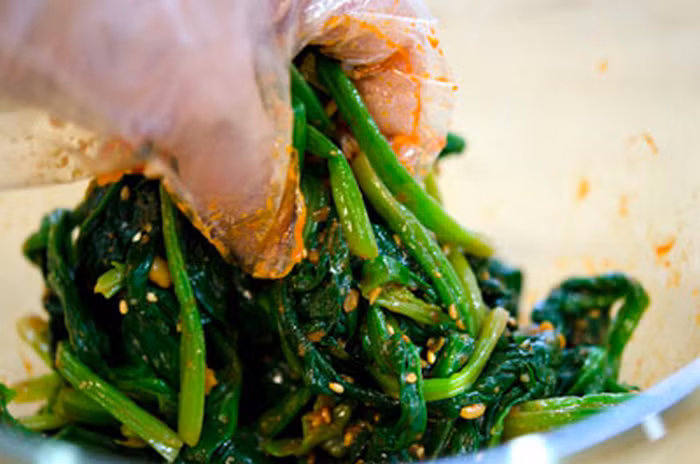 Rau cải bó xôi cắt rễ, rửa sạch, cắt khúc vừa tầm ăn. Chần trong nước sôi khoảng 1-2 phút. Giá đỗ cũng chần trong nước sôi 1-2 phút. Sau khi chần đổ ra giá cho róc nước, để nguội để ráo nước. Ảnh: Daynauan.