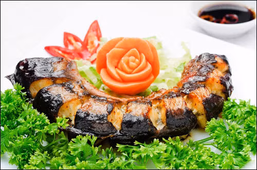 Đặt cá vào vỉ nướng rồi cho vào lò nướng. Trong quá trình nướng dùng cọ quét đều nước ướp cá và dầu ăn lên cá để cá chín mềm. Nướng đến khi miếng cá ngả màu vàng đều là được. Ăn cá nướng cùng muối tiêu chanh và lá húng lủi. Ảnh: 7monngonmoingay.net.