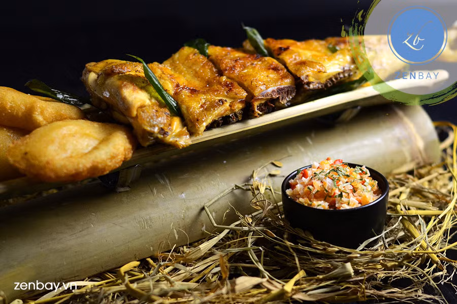 Trộn đều tất cả các loại gia vị: sả, gừng, tía tô, hạt nêm, bột ngọt, đường, mật ong ướp cùng với gà trong 15 phút. Trước khi cho gà vào ống tre thì đem ra nướng sơ trên than. Ảnh: Zenbay.vn.