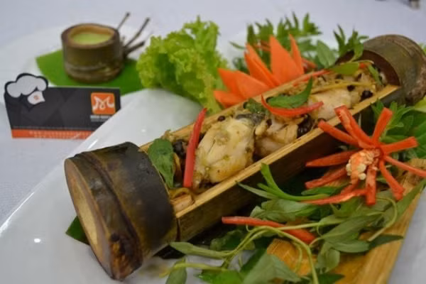 Dùng lá chuối đậy kín ống tre sau đó cột chặt lại. Đặt ống tre lên than củi hồng để nướng, khi nướng nhớ xoay đều ống tre. Thưởng thức cùng muối tiêu chanh và rau răm. Ảnh: danang.huongnghiepaau.com.