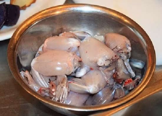 2. Ếch nướng ống tre. Nguyên liệu: Đùi ếch, sả, rau răm, hành tím, tỏi, gừng, ớt, tiêu xanh, hành lá, dầu hào. Dụng cụ: Ống tre, lá chuối, lò nướng (bếp than). Đùi ếch rửa sạch, chặt miếng cho vào bát rồi thêm hạt nêm và ít dầu ăn vào trộn đều để ướp. Ảnh: lamsao.com.