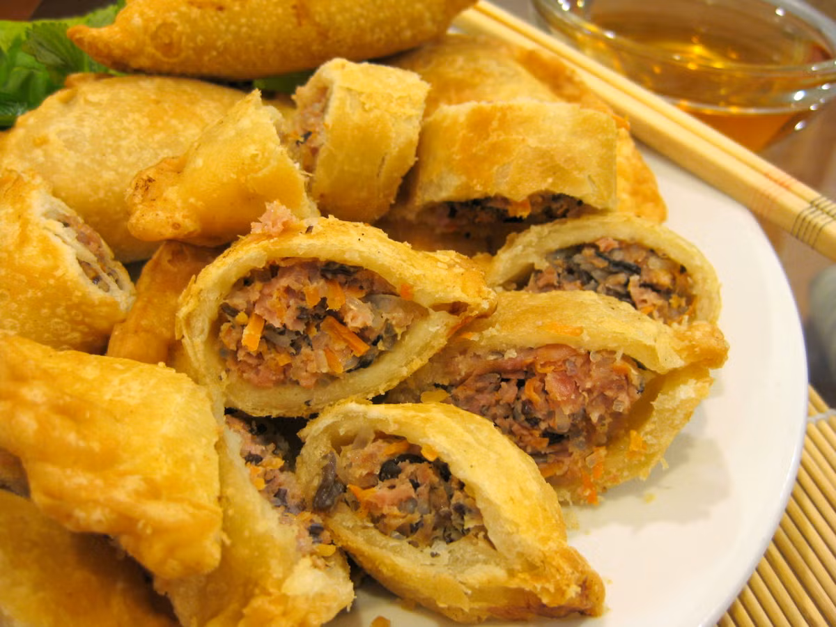 Cán bột mỏng và cho phần nhân thập cẩm vào giữa. Sau đó, bạn gấp đôi miếng vỏ bánh, bóp nhẹ cho mép vỏ hai nửa dính vào nhau. Đun sôi chảo ngập dầu, thả từng chiếc bánh vào chiên đến khi bánh vàng giòn cả hai mặt thì cho ra giấy thấm dầu. Ảnh: xinhxinh.vn.