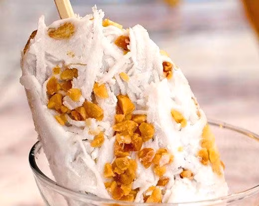 Bọc màng bọc thực phẩm lại cho kín toàn bộ phần kem. Đem hộp kem bỏ vào trong ngăn đá tủ lạnh từ 2-4 tiếng là có thể ăn được. Sau đó, lấy kem ra và dùng dao cắt kem thành các miếng vừa ăn rồi bày lên trên đĩa, ly để thưởng thức món kem chuối lạc thơm ngon hấp dẫn. Ảnh: GiaDinh.TV.