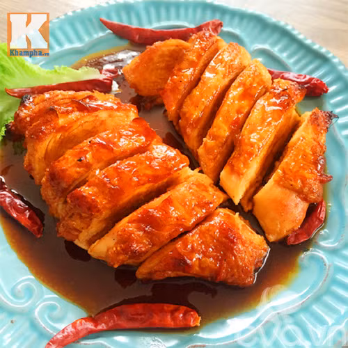 Pha nước sốt. Nước mắm, đường, ớt bột và 1 thìa canh nước sôi hoà cho tan đều trong một bát. Tiếp theo, cho phần nước mắm vào chảo và đun đến khi hỗn hợp nước mắm sốt chua cay mặn ngọt sệt lại. Ức gà sau khi chiên và bớt nóng, dùng dao sắc rồi nhẹ nhàng khía thành tường miếng thịt vừa phải và rưới nước sốt sao cho phủ đều lên bề mặt của miếng thịt gà. Ảnh: Khampha.