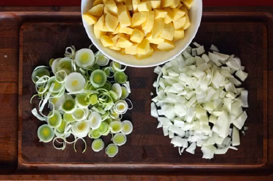 3. Món súp khoai tây mịn. Nguyên liệu: Khoai tây, sữa tươi không đường, muối, tiêu, hành boa rô, bơ, ngò tây. Chuẩn bị nguyên liệu. Rửa sạch hành boa rô, cắt phần đầu trắng thành từng lát mỏng. Khoai tây rửa sạch, gọt vỏ, cắt miếng vuông. Ảnh: toinayangi.vn.