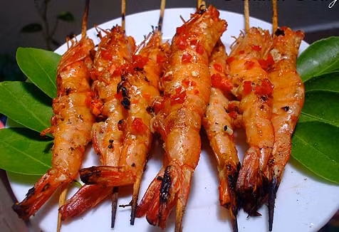 Cho hỗn hợp nước sốt vào ướp với tôm khoảng 30 phút. Sau đó cho lên bếp nướng than hoa không khói nướng đều. Bạn cũng có thể nướng trước hoặc vừa ăn vừa nướng là ngon nhất. Ảnh: phunutoday.vn.