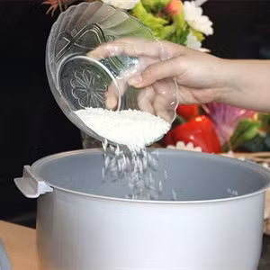 6. Cơm hấp Coca Cola. Nguyên liệu: Gạo, lá chuối, dầu ăn, muối, cá cơm, Coca Cola, hành tây, nguyệt quế, hành lá, ớt. Gạo vo sạch. Khô cá cơm, rửa sạch, để ráo. Hành tây bóc vỏ, cắt lát mỏng. Hành lá và ớt cắt nhỏ. Đun nóng dầu ăn rồi cho 2/3 chỗ hành tây vào xào thơm thì tắt bếp. Ảnh: naungon.com.