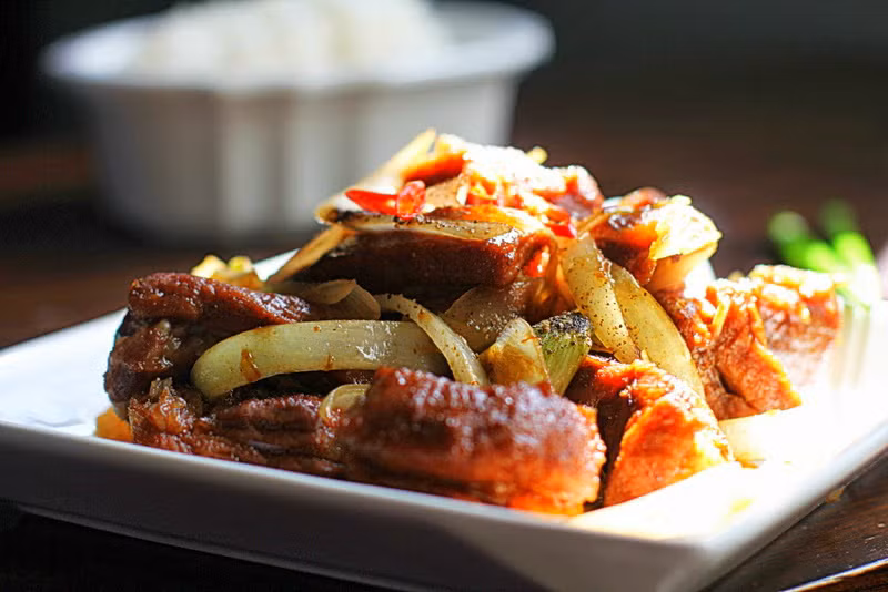 Trong 1 chén khác, cho cà phê tiêu, ngũ vị hương, ớt bột, muối, khuấy đều. Cho sườn heo vào hỗn hợp, trộn đều, để 15 phút. Làm nóng chảo với dầu ăn, cho sườn heo vào, chiên vàng giòn 2 mặt. Cho sườn heo, hỗn hợp vào nồi áp suất, nấu nhiệt độ thấp khoảng 8 giờ, tắt bếp. Ảnh: 2monngonmoingay.com.