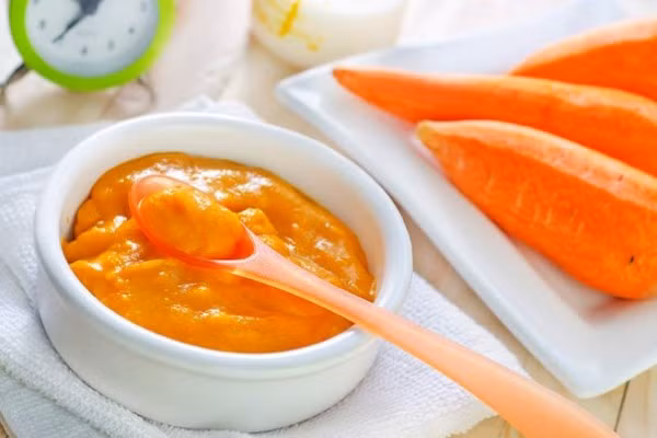 Nguyên liệu gồm cà rốt, cam, nước dừa, gia vị. Cà rốt rửa sạch, gọt vỏ nạo nhỏ và cho vào máy xay cùng nước cam vắt, nước dừa. Thêm gia vị vừa miệng rồi đun sôi nhỏ lửa khoảng 30 phút. Khi súp mịn thì tắt bếp. Ảnh: Vhay.