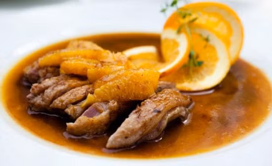 Bắc nồi lên bếp, đun trên ngọn lửa vừa, khi nồi nước xốt nóng lên, cho tiếp bột ngô đã pha vào. Khuấy đều cho tan hết các gia vị. Khi nước xốt sôi trở lại, bắc nồi ra ngoài. Cuối cùng tưới nước xốt lên thịt vịt, rắc một chút vỏ cam lên trên. Ảnh: vitomsau.com.