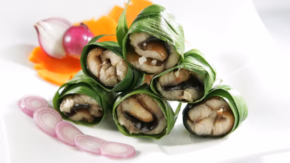 2. Cá nướng lá dứa. Cá làm sạch, cắt khúc rồi ướp hạt nêm, đường, nước mắm, dầu ăn… Dùng lá dứa cuộn tròn quanh mình cá. Sau đó dùng tăm xiên vào miếng cá để lá dứa không bị bung ra. Cho cá lên vỉ, nướng chín vàng đều. Món ăn dùng với tương ớt rất hấp dẫn. Ảnh: Knorr.com.vn.