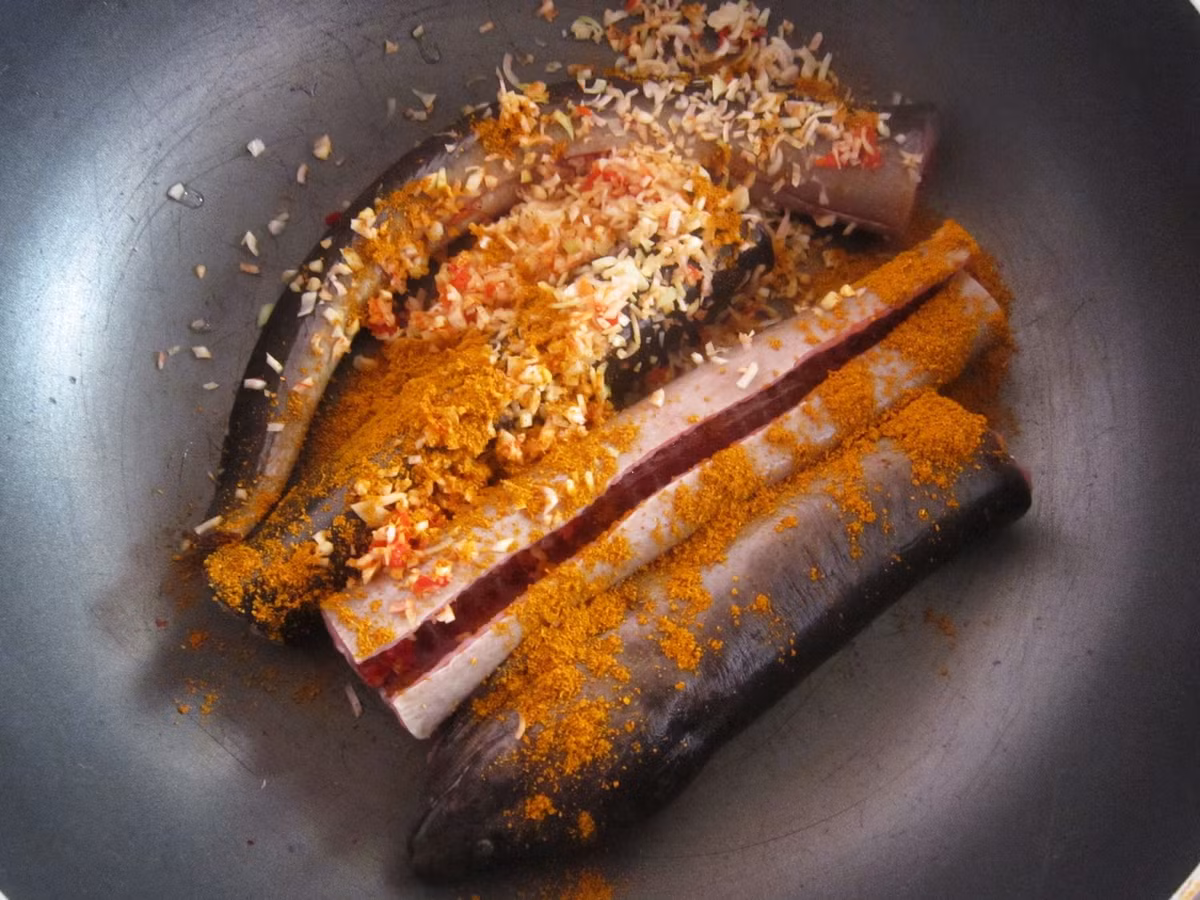 2. Lươn om rau ngổ. Nguyên liệu: Lươn, rau ngổ, sả, ớt, nước cốt dừa, gia vị: nước mắm, muối, hạt nêm, đường và giấm. Lươn làm sạch, rửa qua với giấm cho sạch nhớt và bớt mùi tanh. Dùng dao xẻ xéo phần thịt lươn, ướp lươn cùng hạt nêm và nước mắm trong 30 phút. Ảnh: fruitiecake.blogspot.com.