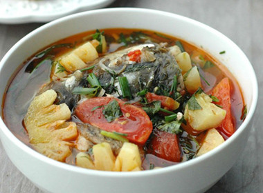 Cho thêm 1 quả dứa bổ nhỏ vào, đun sôi. Cho cá vào cùng gia vị đun cho chín đều. Cho thêm các gia vị và giá cùng các loại rau vào rồi tắt bếp. Ảnh: monngonbonmua.com.