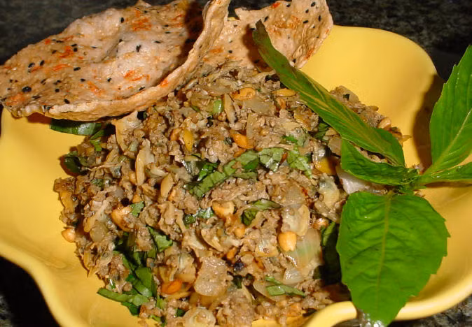 4. Rắn xúc bánh đa: Vàng giòn màu nghệ, thơm lừng mùi tỏi, sả, ớt. Rắn được bằm hoặc xay nhuyễn, tỏi khử, xào rắn trên lửa lớn đều. Lá chanh và lá điều non thái mỏng, rải đều trên mặt. Ăn kèm với món này có bánh đa hoặc bánh phồng tôm chiên. Ảnh: Saigongame.com.