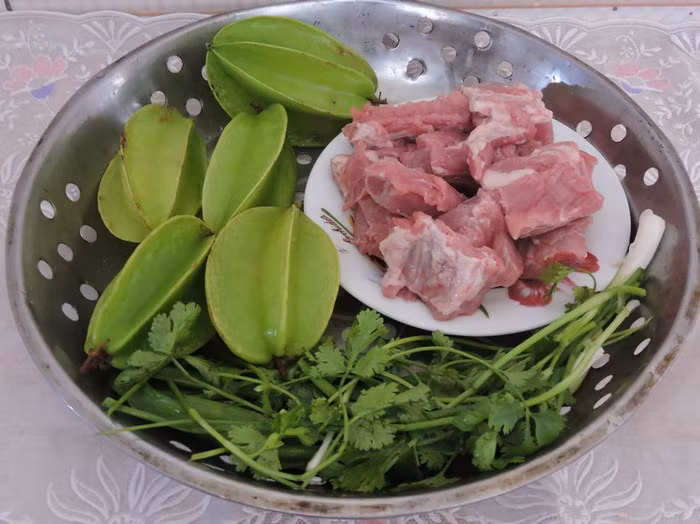 Sườn kho khế. Cho chảo lên bếp, đợi chảo nóng rồi cho dầu và đường để làm nước hàng. Tiếp tục cho tỏi, sả, ớt băm vào phi thơm rồi cho sườn vào xào săn lại. Sau cùng cho thêm nước dừa vào đảo đều, đậy nắp đun với lửa nhỏ để miếng sườn được ngấm đều và mềm. Ảnh: Tienphong.