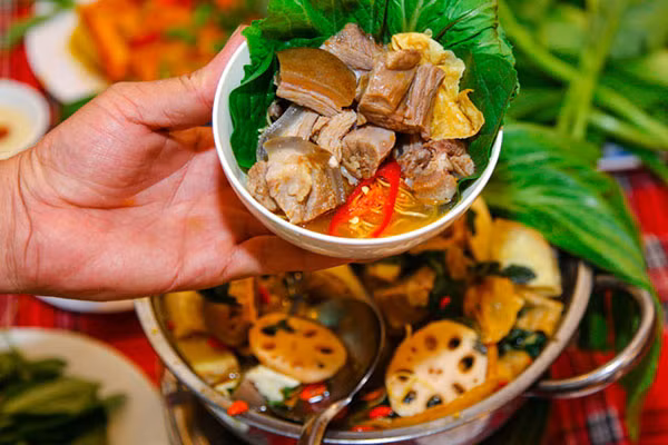 Sau khi đun sôi 10 phút tiếp tục cho khoai môn và củ sen vào đun với lửa nhỏ trong 15 phút, nêm nếm gia vị cho vừa miệng rồi tắt bếp. Nước dùng dê vừa chuẩn bị ở trên trút hết vào nồi lẩu sau đó đặt lên bếp, bạn có thể chuẩn bị bếp gas mini hoặc bếp điện để ăn lẩu. Những nguyên liệu ăn lẩu: rau nhúng, đậu phụ, váng đậu, nấm được chuẩn bị và dọn ra xung quanh nồi lẩu. Ảnh: phunudep.com.